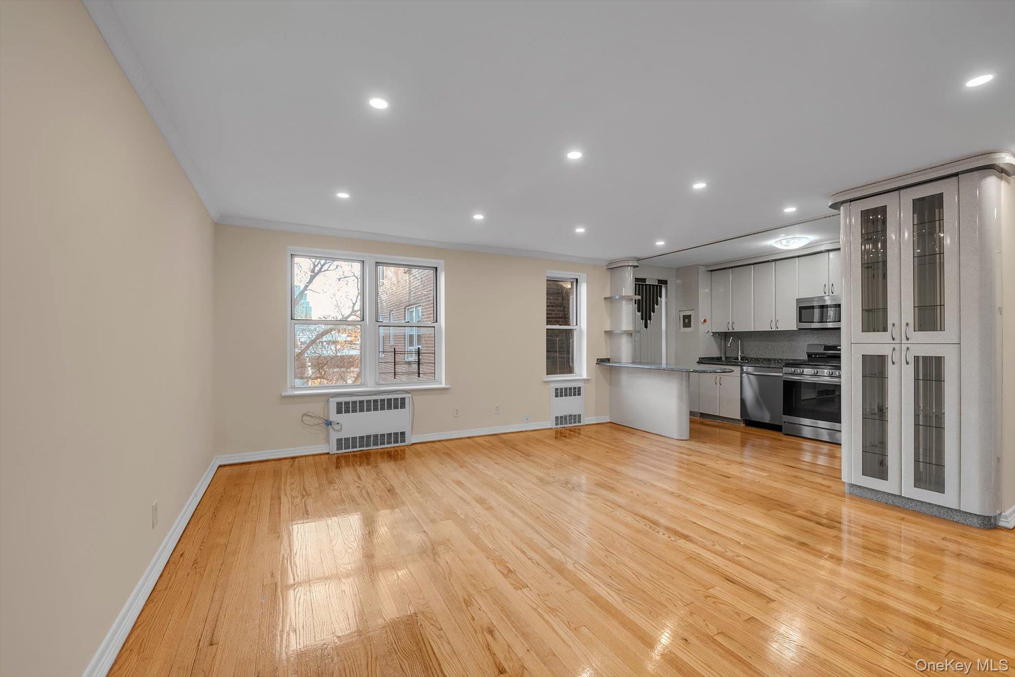 65-35 Yellowstone Boulevard, Unit 4G Queens, NY 11375 - Photo 4 of 10 Unfurnished living room with light wood finished floors, recessed lighting, radiator heating unit, and ornamental molding