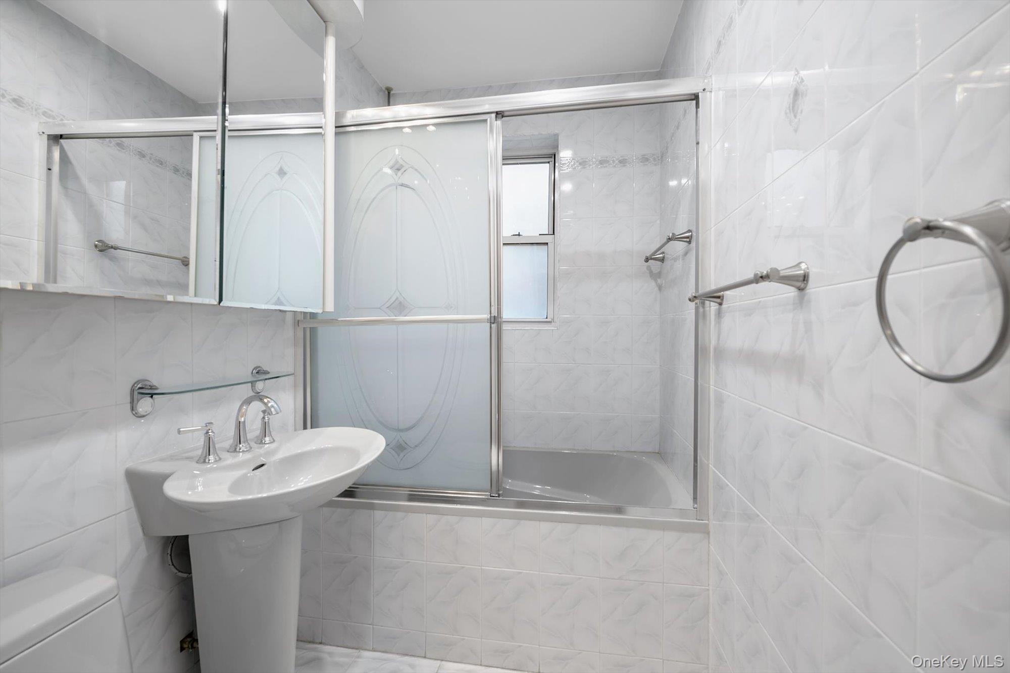 65-35 Yellowstone Boulevard, Unit 4G Queens, NY 11375 - Photo 9 of 10 Bathroom with tile walls, tiled shower / bath combo, and backsplash