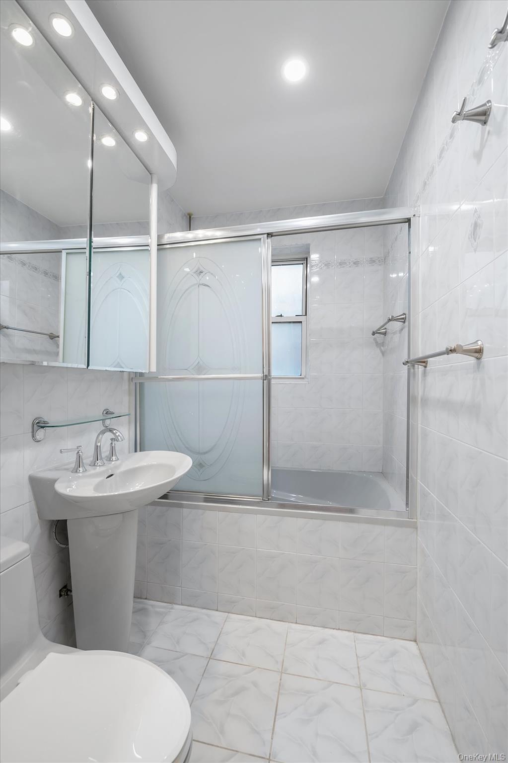 65-35 Yellowstone Boulevard, Unit 4G Queens, NY 11375 - Photo 10 of 10 Bathroom with tile walls, tiled shower / bath, recessed lighting, marble look tiles, and tasteful backsplash