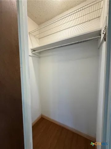 a view of an empty room with a cabinet and a window