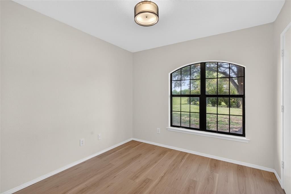 509 Brookside Court Burleson, TX 76028 - Photo 12 of 18 an empty room with wooden floor and windows