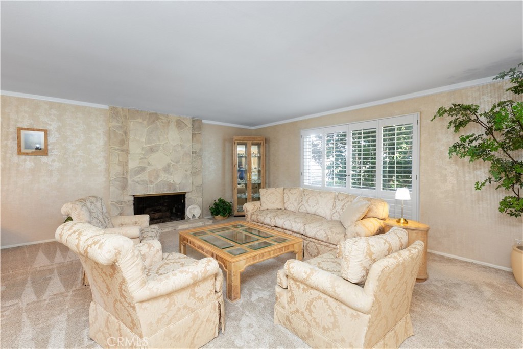 8224 Seranata Drive Whittier, CA 90605 - Photo 28 of 55 a living room with furniture a fireplace and a floor to ceiling window