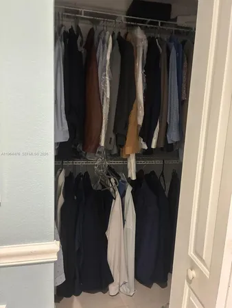 a view of walk in closet with clothes and shoes