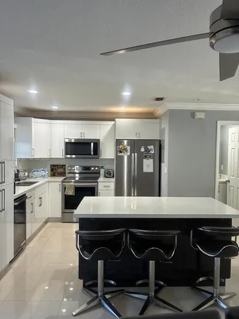 a kitchen with a table chairs microwave and cabinets