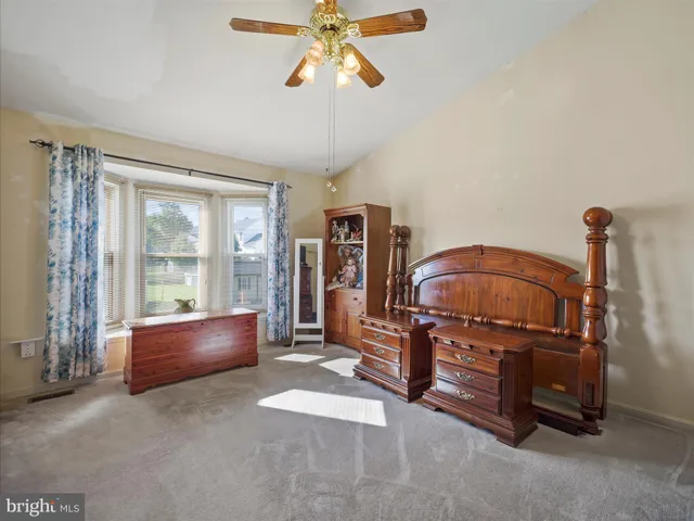 a living room with furniture a ceiling fan and a window
