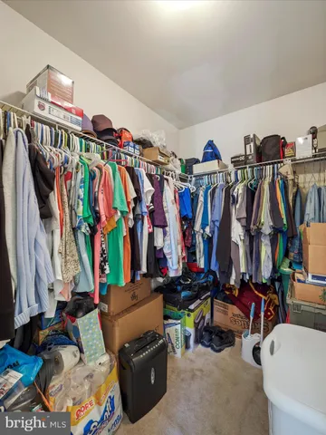 a view of walk in closet with clothes