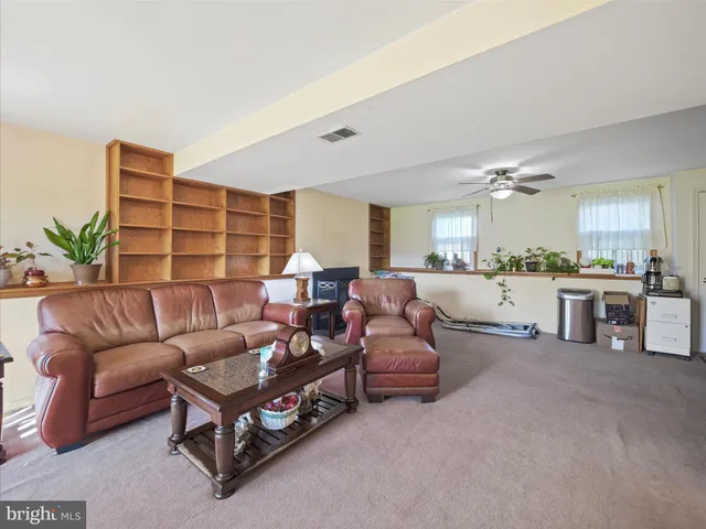 a living room with furniture and view of kitchen