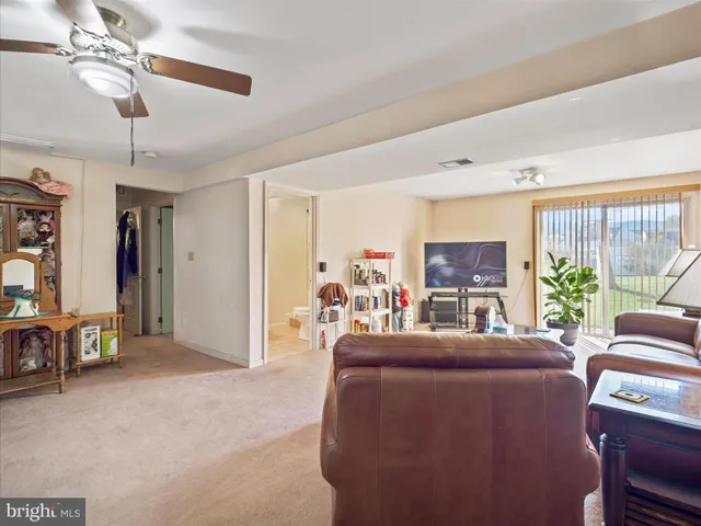 a living room with furniture a ceiling fan and a window