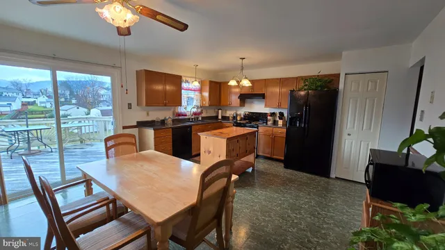 a view of a dining room with furniture a chandelier and large window