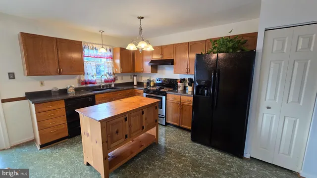 a kitchen that has a sink stainless steel appliances a counter space and cabinets