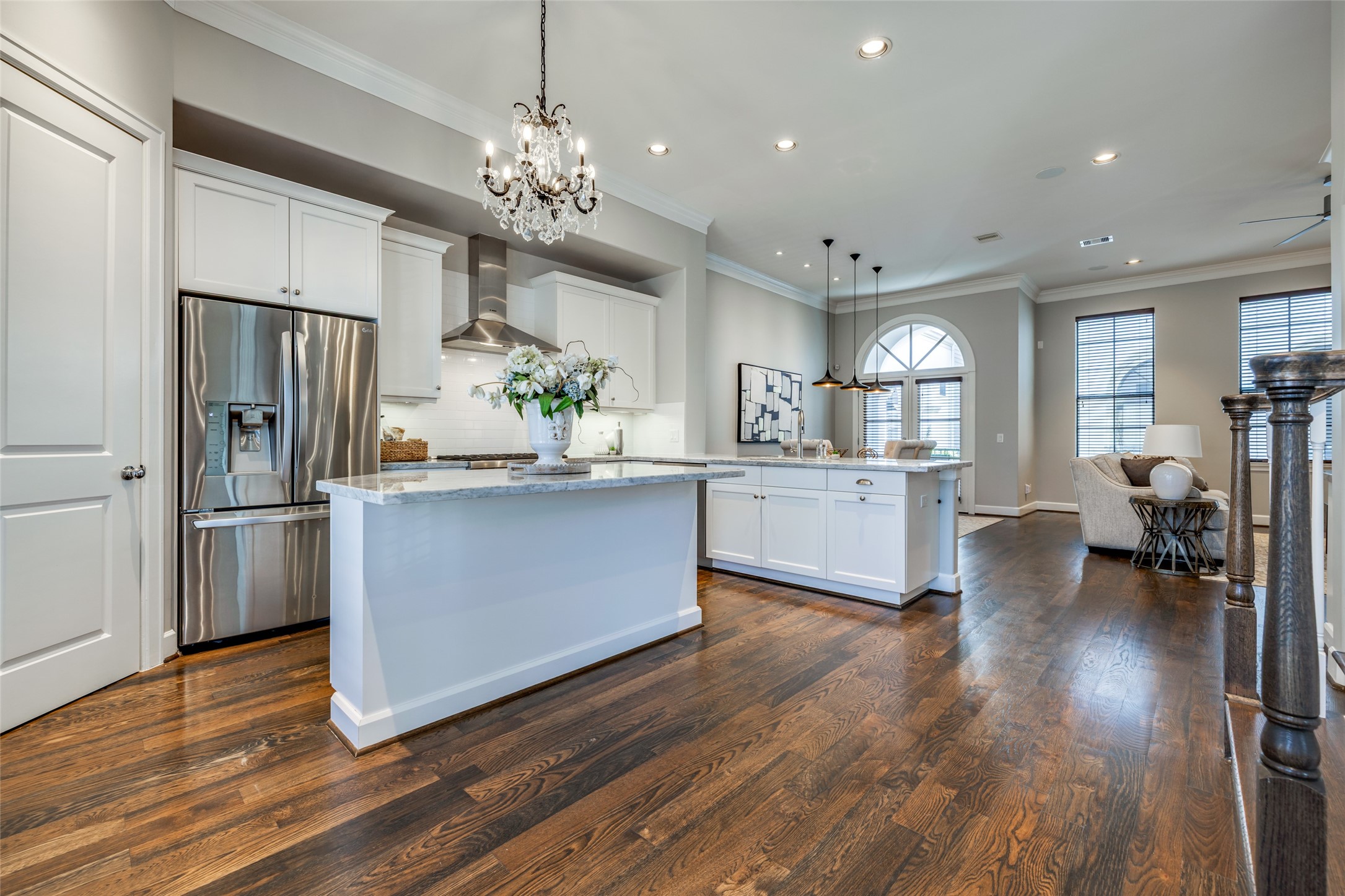 604 Knox Street Houston, TX 77007 - Photo 11 of 42 This elegant kitchen and living area features hardwood floors, a spacious island with granite countertops, stainless steel appliances, and stylish lighting, creating a bright and modern open-concept space perfect for entertaining.