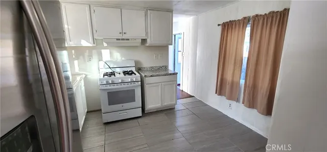 a kitchen with white cabinets and white appliances