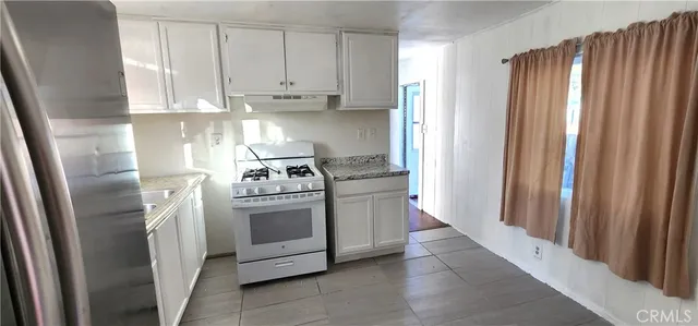 a kitchen with stainless steel appliances granite countertop a refrigerator and a stove