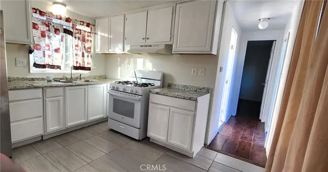 a kitchen with granite countertop cabinets stainless steel appliances and a sink