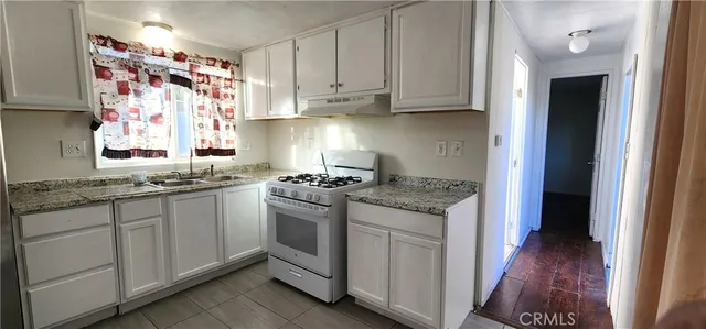 a kitchen with granite countertop cabinets stainless steel appliances and a wooden floor