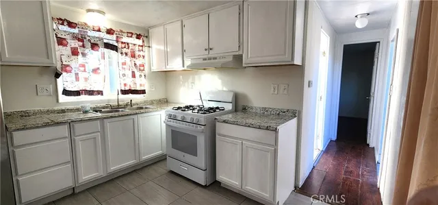 a kitchen with granite countertop cabinets stainless steel appliances and a wooden floor