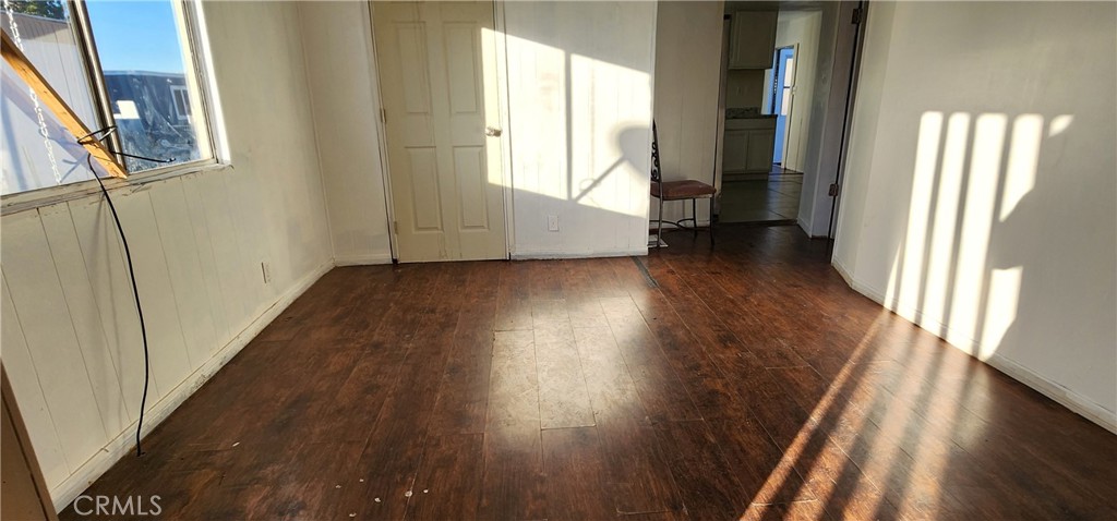 8562 C Avenue, Unit 48 Hesperia, CA 92345 - Photo 23 of 37 a view of a hallway to an empty room with wooden floor and a window