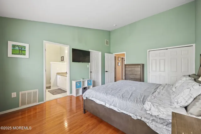 a spacious bedroom with a bed and a flat screen tv