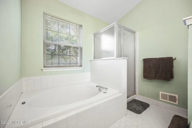 a bathroom with a tub sink and a mirror