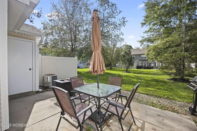 a view of a patio with a table chairs and a yard