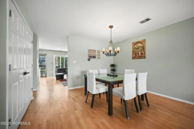 a view of a dining room with furniture wooden floor and a chandelier
