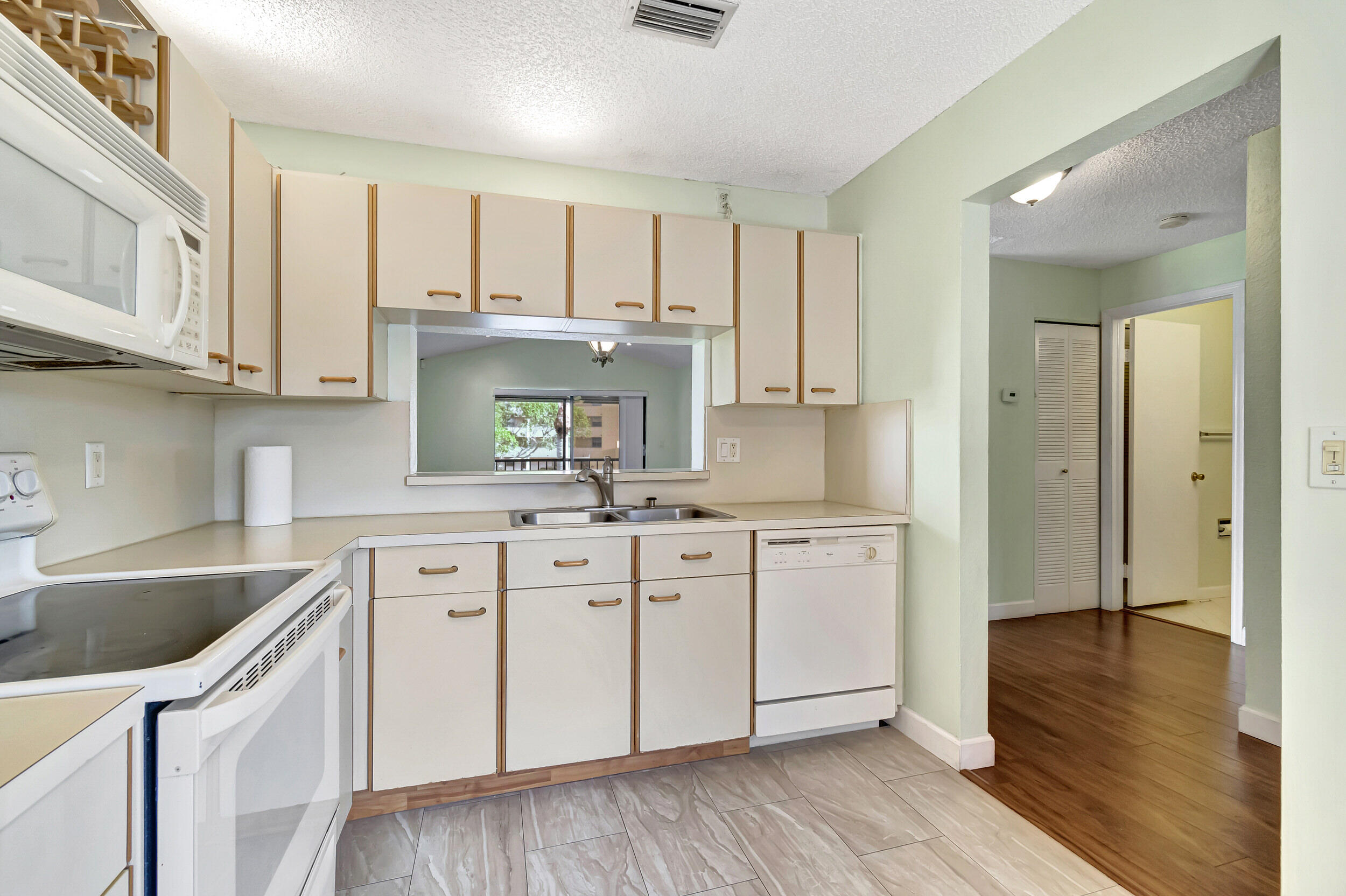 351 Club Circle, Unit 207 Boca Raton, FL 33487 - Photo 9 of 28 a kitchen with white cabinets and sink