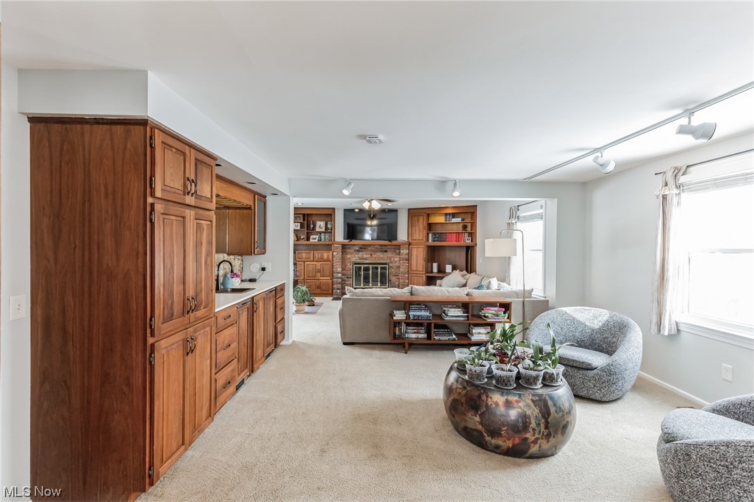 1429 Bell Road Chagrin Falls, OH 44022 - Photo 12 of 42 Great room with a brick fireplace, light carpet, track lighting, and a healthy amount of sunlight