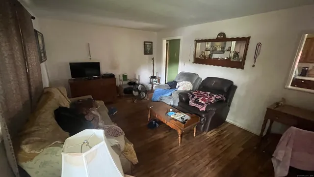 a living room with furniture wooden floor and a flat screen tv