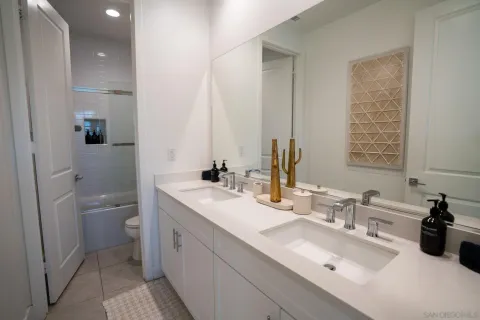a bathroom with a double vanity sink toilet and a mirror