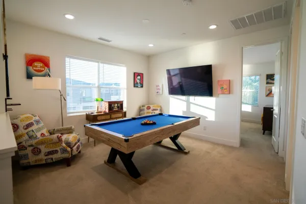 a living room with furniture pool table and a flat screen tv