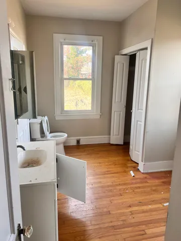 a living room with stainless steel appliances wooden floor and a window
