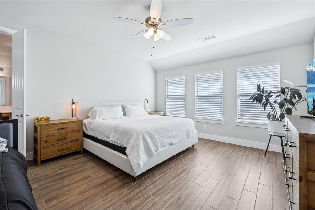 800 Majors Road Van Alstyne, TX 75495 - Photo 19 of 40 Bedroom featuring wood finish floors, visible vents, a ceiling fan, baseboards, and vaulted ceiling