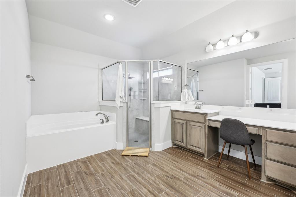 800 Majors Road Van Alstyne, TX 75495 - Photo 21 of 40 Bathroom with a stall shower, vanity, a garden tub, and wood tiled floor