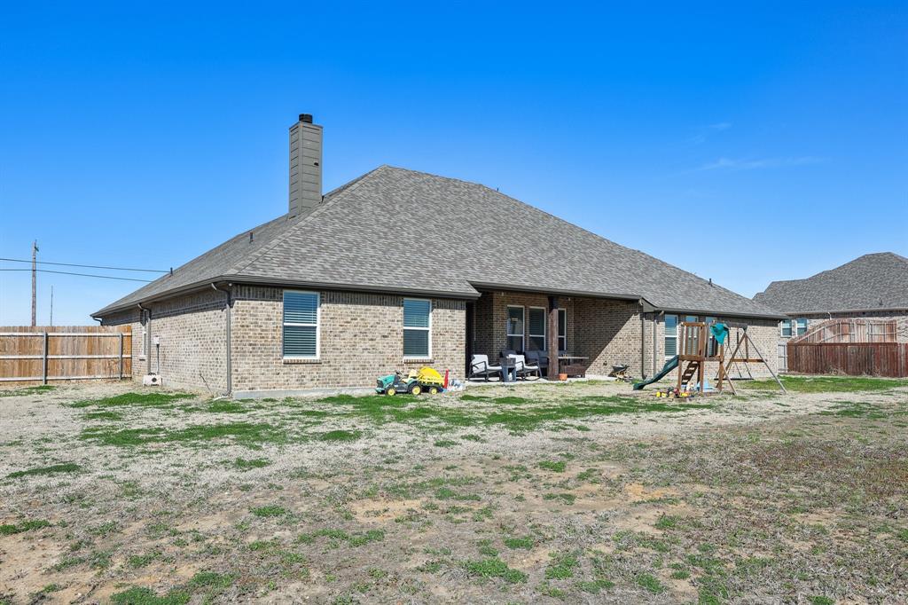 800 Majors Road Van Alstyne, TX 75495 - Photo 36 of 40 Rear view of house featuring brick siding, a fenced backyard, a chimney, and a playground
