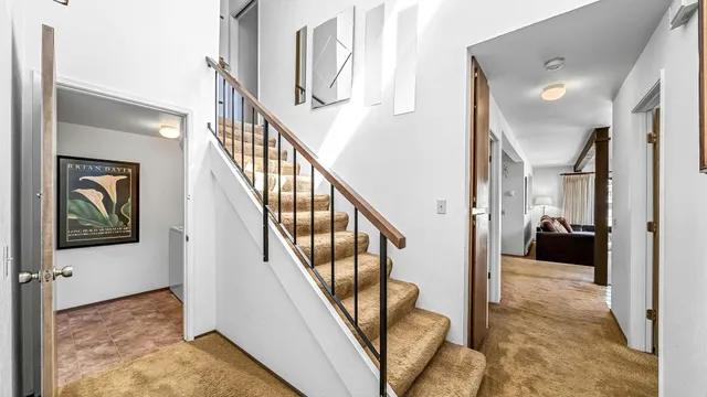 a view of a hallway with wooden floor and staircase