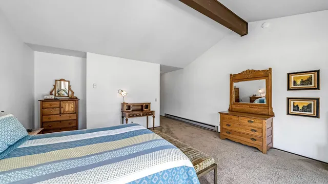 a bedroom with a bed and a dresser in it