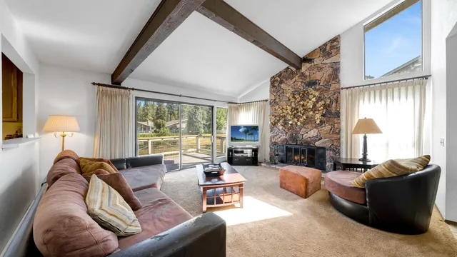 a living room with furniture fireplace and a large window