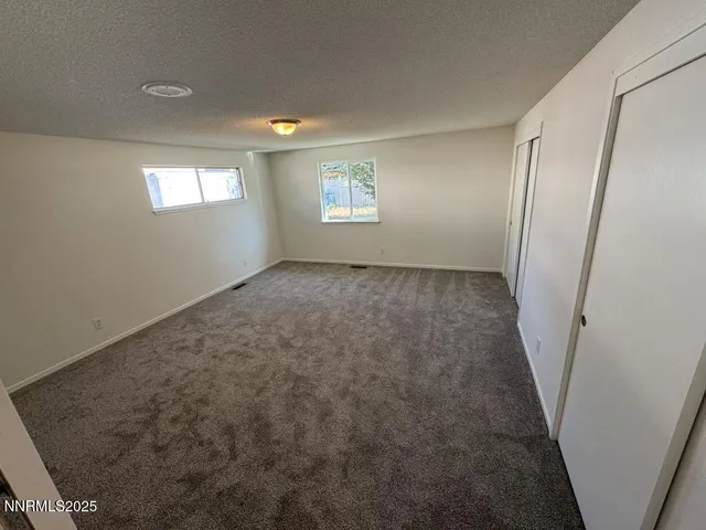 an empty room with windows and closet