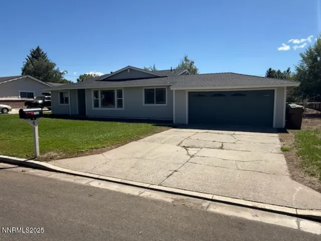 a front view of house with yard and trees in the background