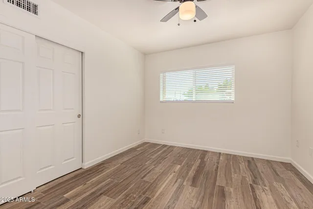 an empty room with a window and wooden floor