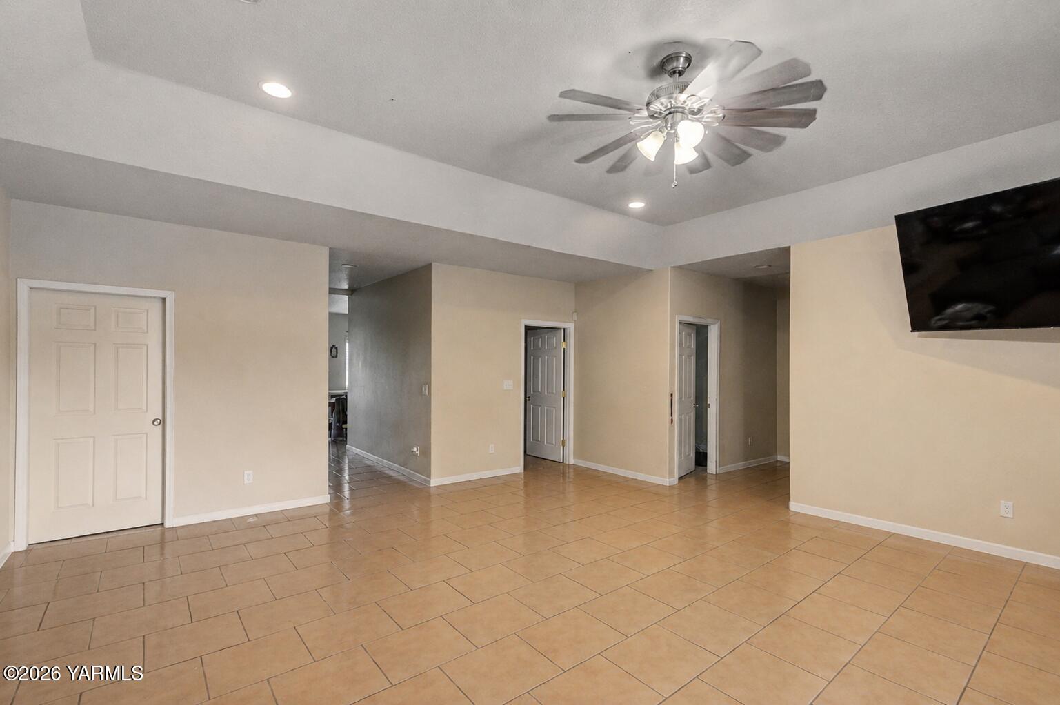 1811 Beam Road Granger, WA 98932 - Photo 7 of 26 a view of an empty room with a ceiling fan a kitchen view and a window