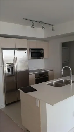 a kitchen with stainless steel appliances a refrigerator and a sink