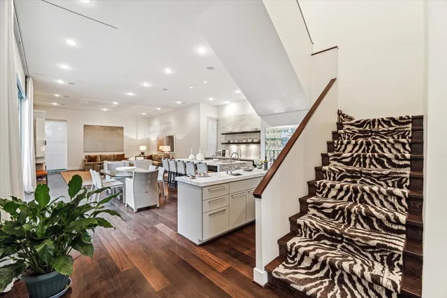 a living room with a dining table chairs and a potted plant