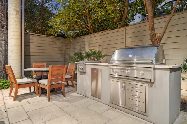 a backyard of a house with barbeque oven and outdoor seating