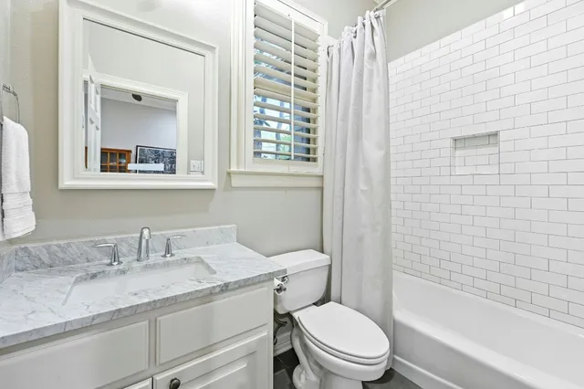 a bathroom with a granite countertop sink a mirror a glass door and shower