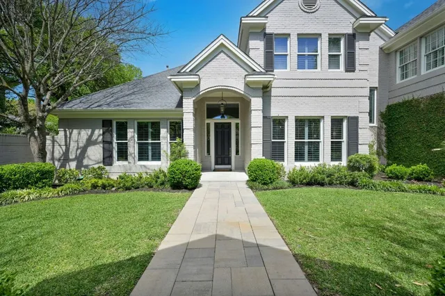 a front view of a house with a yard and potted plants