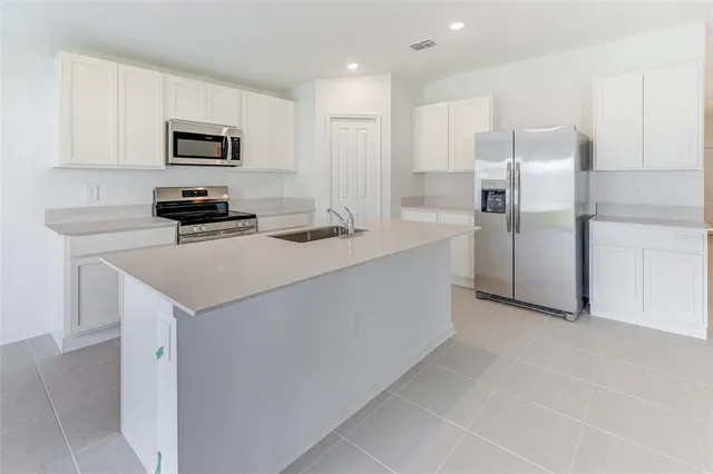 a kitchen with stainless steel appliances granite countertop white cabinets and stove top oven