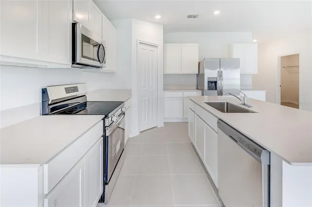 a kitchen with stainless steel appliances granite countertop a sink and a refrigerator