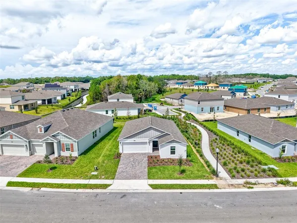 an aerial view of multiple houses with a swimming pool