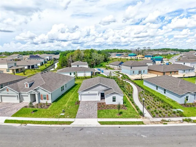 an aerial view of multiple houses with a swimming pool